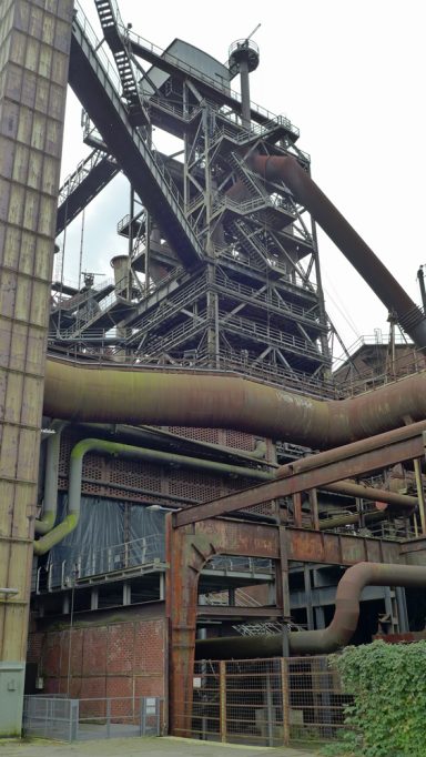 Industrielle Anlage mit hohen Turmstrukturen und sichtbaren Rohren.