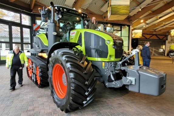 Großer, moderner Traktor mit breiten Reifen, in einer hellen Ausstellungshalle.