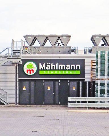 Gebäude mit dem Schriftzug "Mühlmann" und Kühlsystemen auf dem Dach.