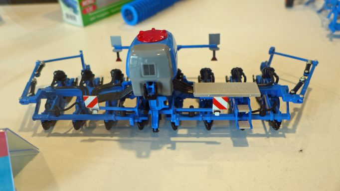 Modell eines landwirtschaftlichen Geräts in Blau und Grau mit verschiedenen Arbeitsteilen.