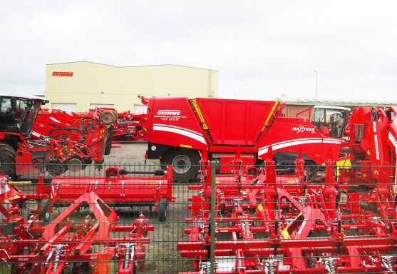 Rote landwirtschaftliche Maschinen auf einem Gelände, darunter ein Futtermischwagen.